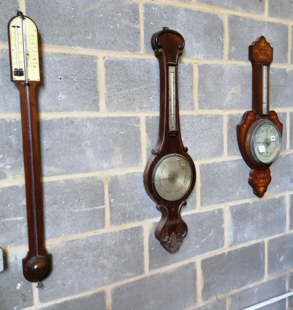 A Victorian rosewood wheel barometer, an Edwardian inlaid aneroid barometer and a stick barometer